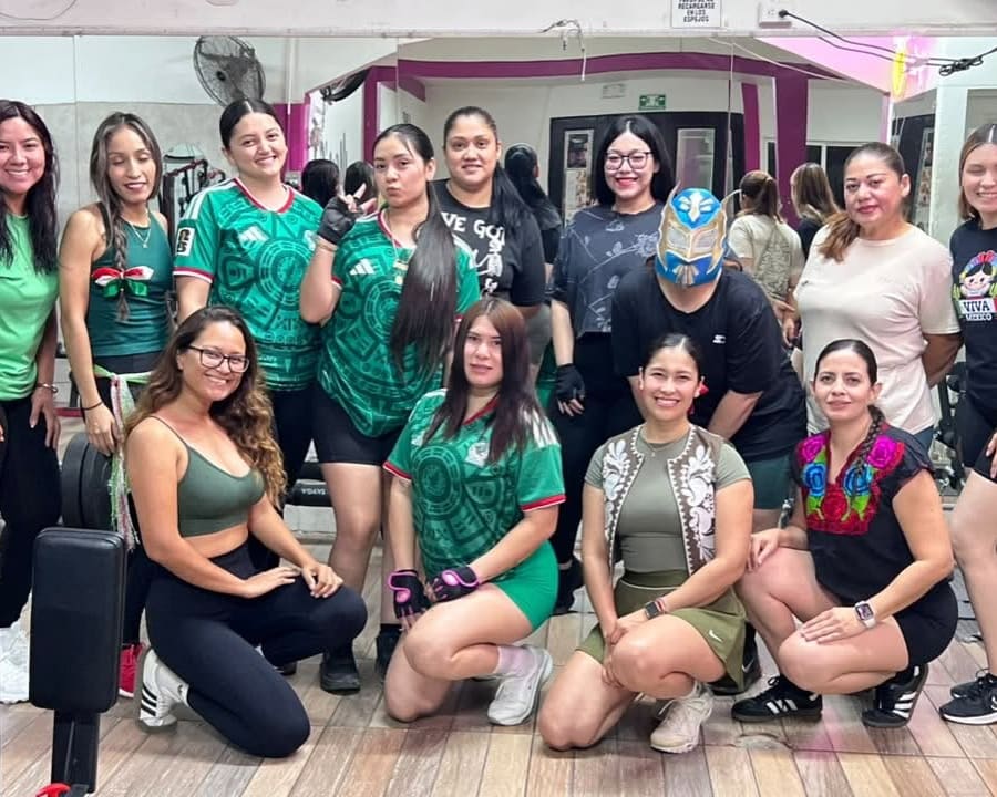 Alumnas con la playera de la Selección Mexicana y una con máscara de luchador, en el gym